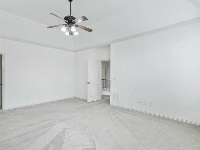 carpeted empty room featuring crown molding, lofted ceiling, and ceiling fan