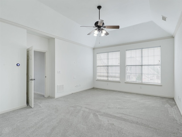 empty room with ornamental molding, light carpet, ceiling fan, and lofted ceiling