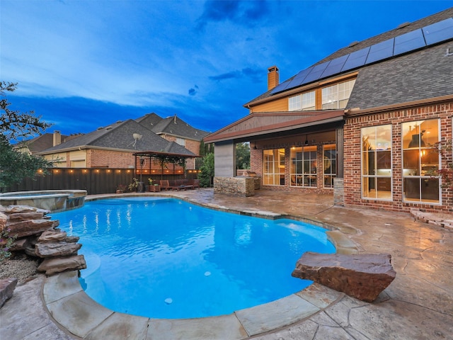 pool at dusk featuring a patio