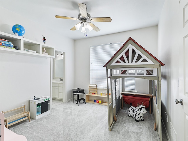 bedroom featuring light colored carpet, ensuite bathroom, and ceiling fan