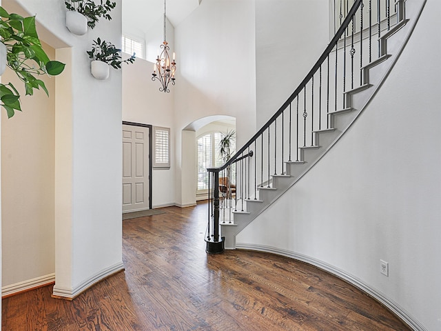 foyer entrance with a high ceiling, a chandelier, and hardwood / wood-style flooring