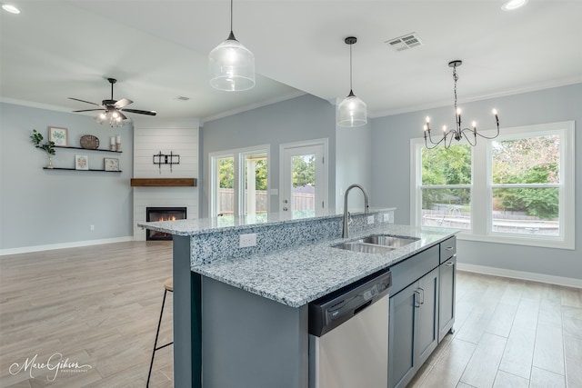 kitchen featuring light wood-type flooring, a large fireplace, ceiling fan with notable chandelier, dishwasher, and sink