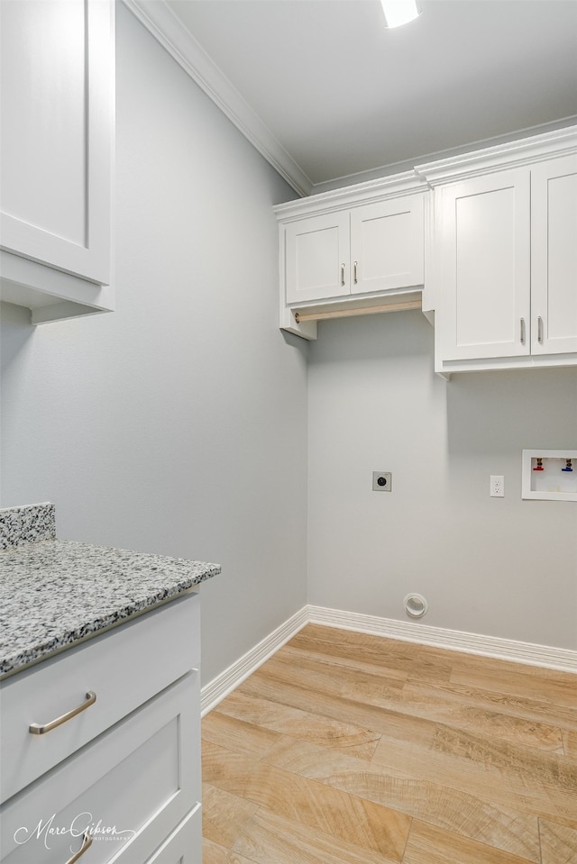 clothes washing area featuring cabinets, crown molding, light hardwood / wood-style flooring, washer hookup, and hookup for an electric dryer