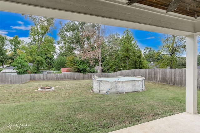 view of yard with a fenced in pool and an outdoor fire pit