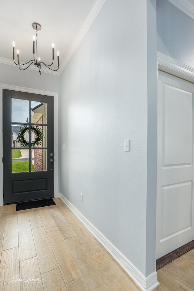 foyer entrance featuring ornamental molding, a chandelier, and light hardwood / wood-style floors