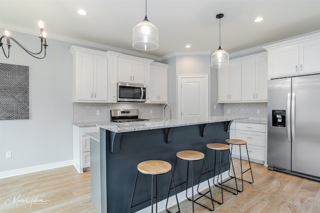 kitchen featuring a center island with sink, appliances with stainless steel finishes, a breakfast bar, white cabinetry, and light wood-type flooring