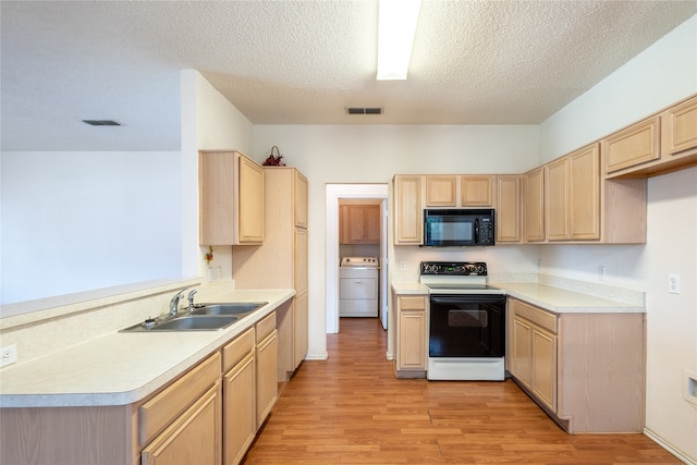 kitchen with light wood-type flooring, white electric range oven, sink, washer / dryer, and a textured ceiling