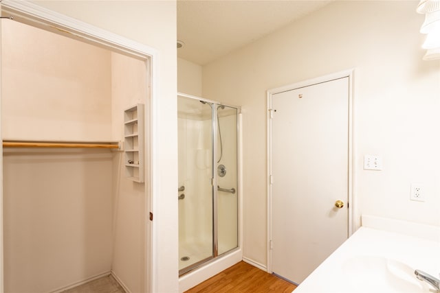 bathroom with a shower with door, hardwood / wood-style flooring, and vanity