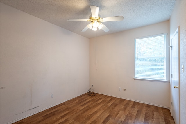 empty room featuring ceiling fan, wood-type flooring, and a textured ceiling