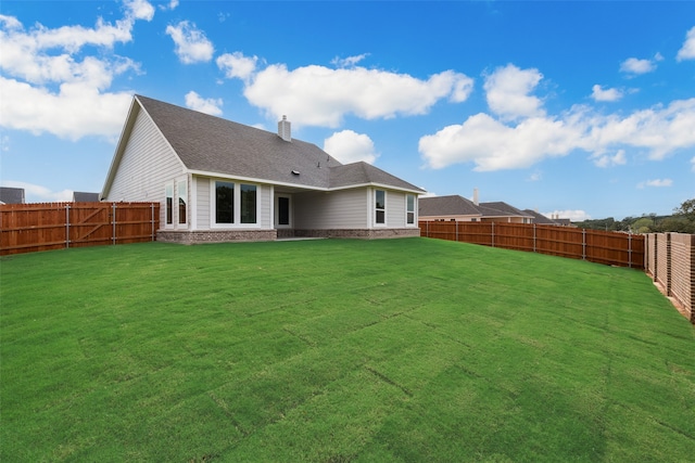 back of property with a yard and a patio area