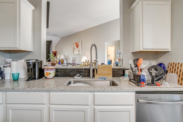 kitchen featuring white cabinets, dishwasher, vaulted ceiling, and sink