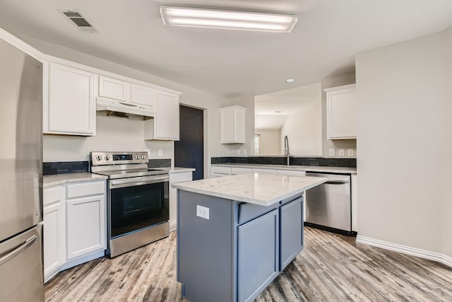 kitchen with a kitchen island, light wood-type flooring, white cabinetry, and stainless steel appliances