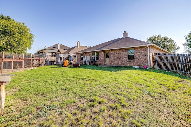 rear view of house featuring a yard