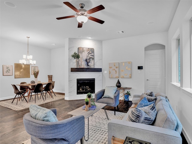 living room with a fireplace, ceiling fan with notable chandelier, and hardwood / wood-style flooring