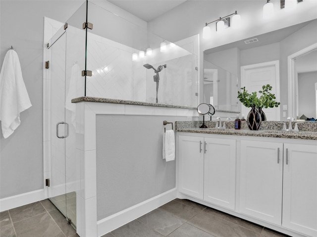 bathroom featuring tile patterned flooring, vanity, and walk in shower