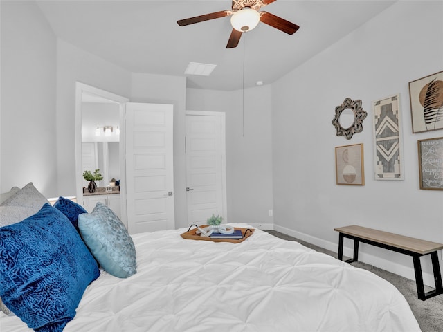 carpeted bedroom with ensuite bath and ceiling fan