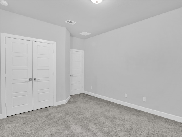 unfurnished bedroom featuring light colored carpet and a closet