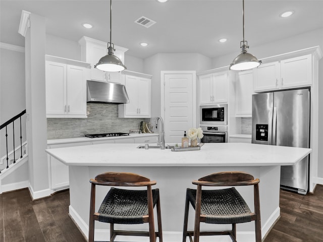 kitchen featuring sink, hanging light fixtures, and a kitchen island with sink