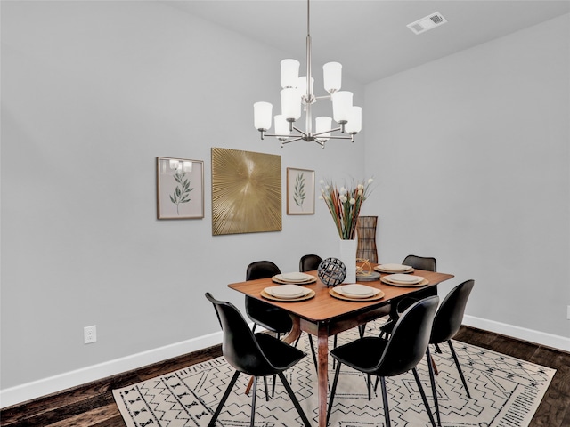 dining area featuring a notable chandelier and dark wood-type flooring