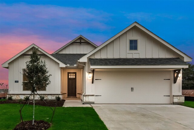 view of front of home featuring a garage and a yard