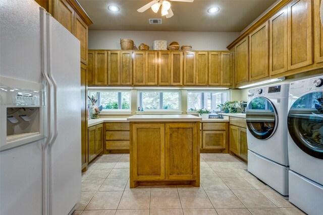 washroom with ceiling fan, cabinets, washer and clothes dryer, and light tile patterned flooring