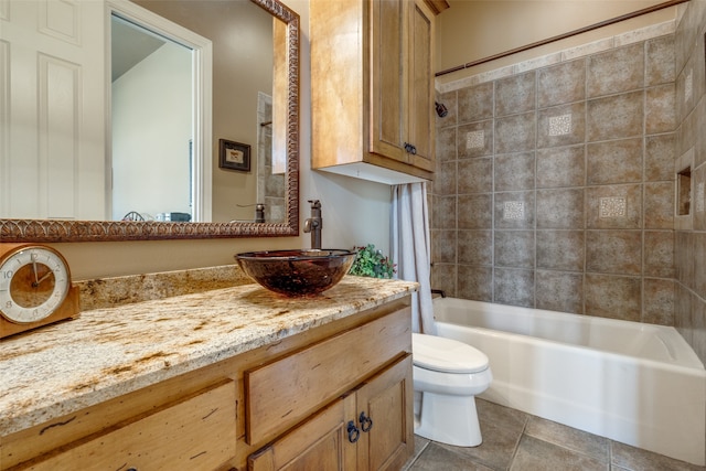 full bathroom with tile patterned floors, toilet, tiled shower / bath combo, and vanity