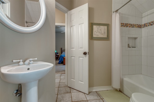 full bathroom featuring shower / bath combination with curtain, tile patterned flooring, toilet, and sink