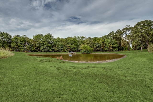 view of home's community featuring a water view and a lawn