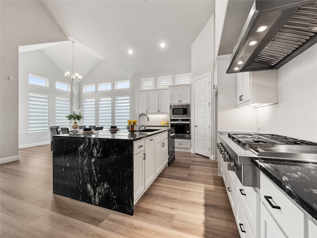 kitchen with appliances with stainless steel finishes, a kitchen island with sink, extractor fan, sink, and a chandelier