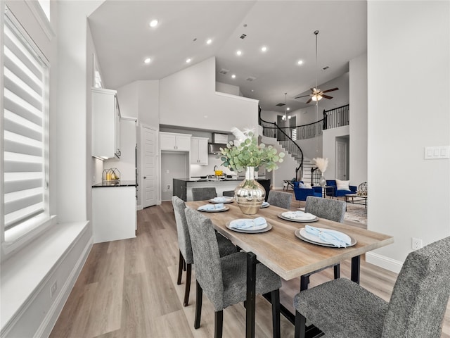 dining room featuring high vaulted ceiling, light hardwood / wood-style flooring, ceiling fan, and a wealth of natural light