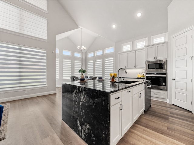 kitchen featuring a notable chandelier, appliances with stainless steel finishes, white cabinetry, and sink