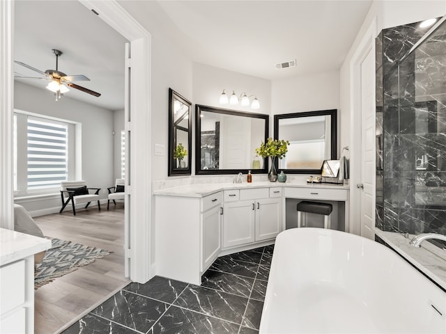 bathroom with plus walk in shower, ceiling fan, wood-type flooring, and vanity