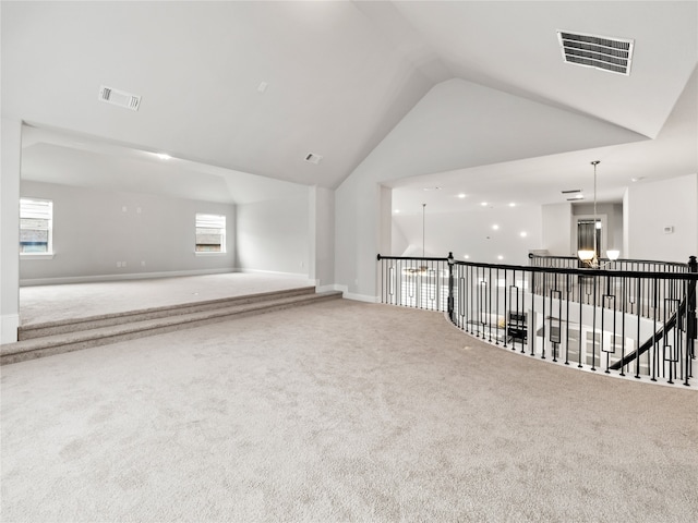 unfurnished room featuring vaulted ceiling, an inviting chandelier, and carpet floors