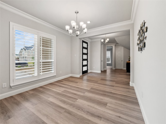 unfurnished dining area featuring crown molding, plenty of natural light, a chandelier, and hardwood / wood-style floors