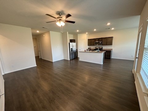 unfurnished living room featuring dark hardwood / wood-style flooring and ceiling fan