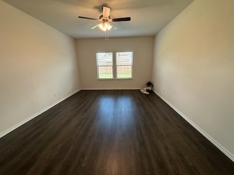 empty room with dark hardwood / wood-style flooring and ceiling fan