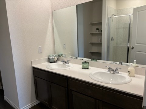 bathroom with vanity and a shower with door