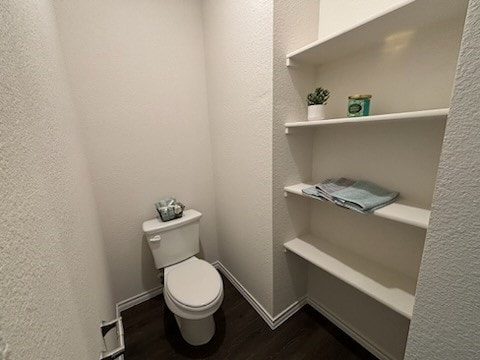 bathroom with toilet and hardwood / wood-style flooring