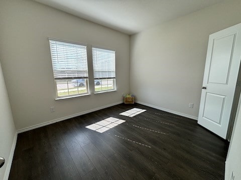 spare room with dark wood-type flooring