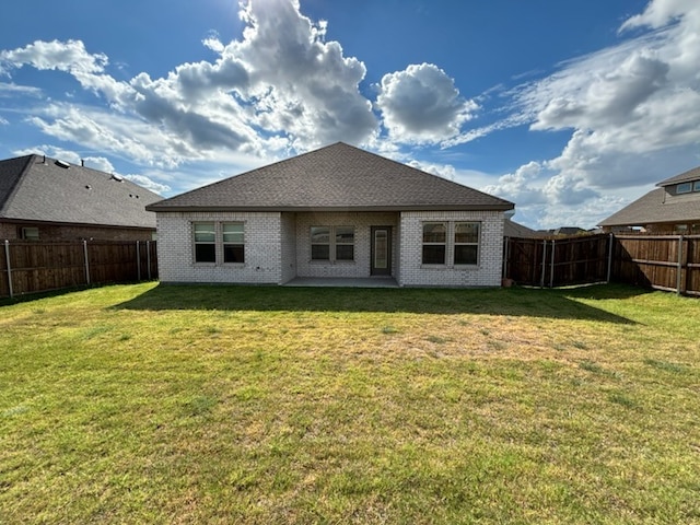 rear view of house featuring a patio area and a yard