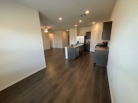 kitchen featuring ceiling fan, range, dark hardwood / wood-style flooring, and a center island