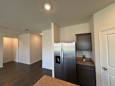 kitchen with stainless steel refrigerator with ice dispenser, dark brown cabinets, and dark hardwood / wood-style floors