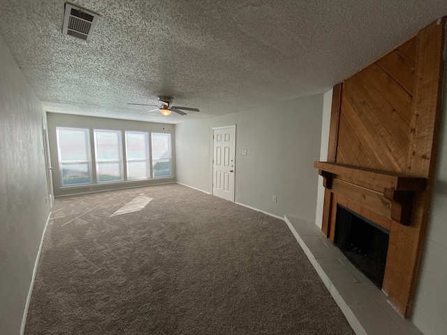 unfurnished living room featuring ceiling fan, light colored carpet, a fireplace, and a textured ceiling