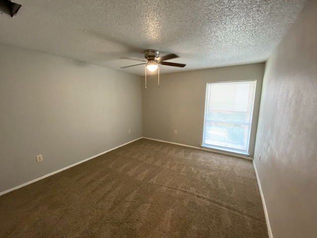 carpeted empty room featuring ceiling fan and a textured ceiling