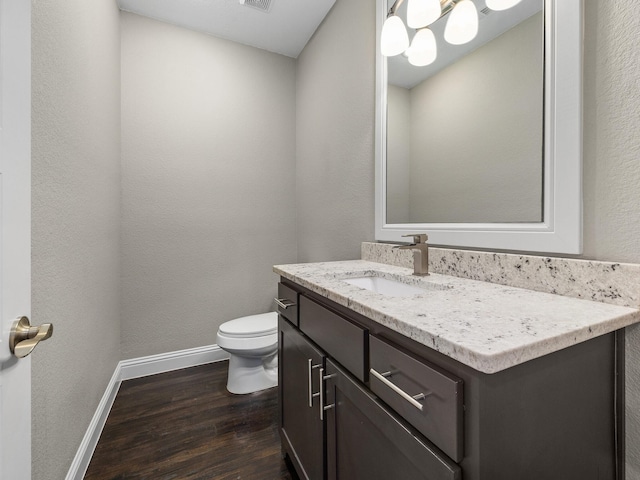 bathroom with vanity, toilet, and hardwood / wood-style floors