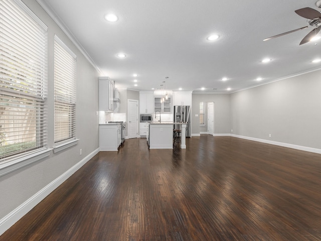 unfurnished living room featuring crown molding, dark wood-type flooring, ceiling fan, and sink