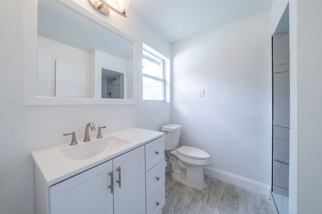 bathroom featuring vanity, toilet, and hardwood / wood-style flooring