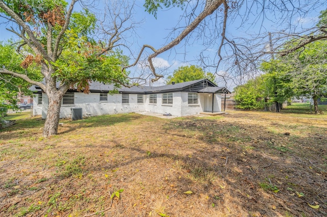 rear view of property with a lawn and central AC unit