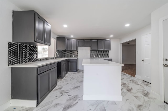 kitchen featuring a center island, gray cabinetry, and tasteful backsplash