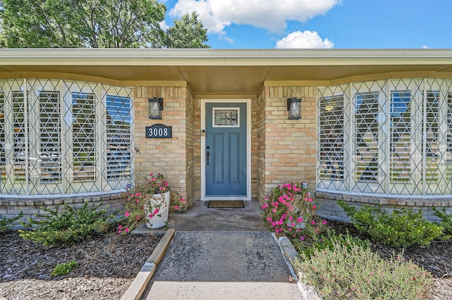 entrance to property featuring brick siding